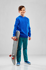 Image showing smiling boy in blue hoodie with skateboard