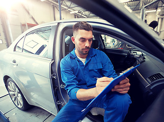 Image showing auto mechanic man with clipboard at car workshop