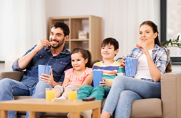 Image showing happy family with popcorn watching tv at home