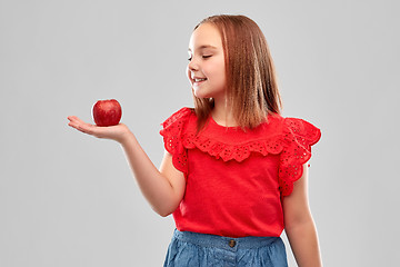 Image showing beautiful smiling girl holding red apple on palm