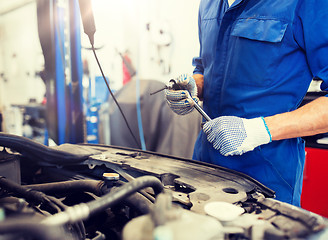 Image showing mechanic man with wrench repairing car at workshop