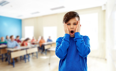 Image showing shocked or terrified boy touching face at school