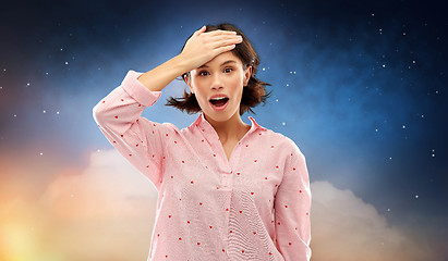 Image showing confused young woman in pajama over night sky