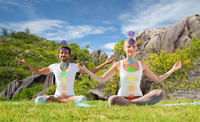 Image showing couple doing yoga in lotus pose with seven chakras