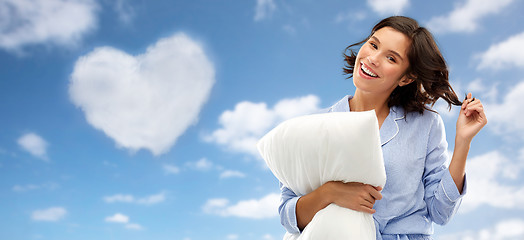 Image showing happy young woman in pajama with pillow over sky