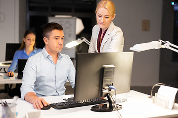 Image showing business team with computer working late at office