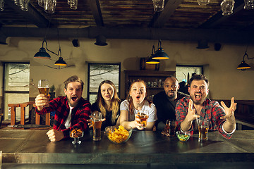 Image showing Sport fans cheering at bar, pub and drinking beer while championship, competition is going