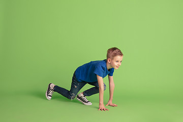 Image showing Happy boy playing and having fun on green studio background, emotions