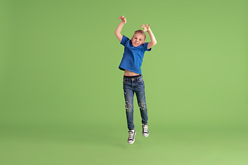 Image showing Happy boy playing and having fun on green studio background, emotions