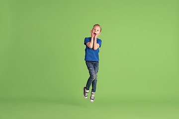 Image showing Happy boy playing and having fun on green studio background, emotions