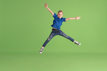 Image showing Happy boy playing and having fun on green studio background, emotions