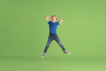 Image showing Happy boy playing and having fun on green studio background, emotions