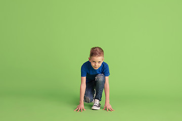 Image showing Happy boy playing and having fun on green studio background, emotions