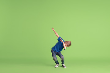 Image showing Happy boy playing and having fun on green studio background, emotions