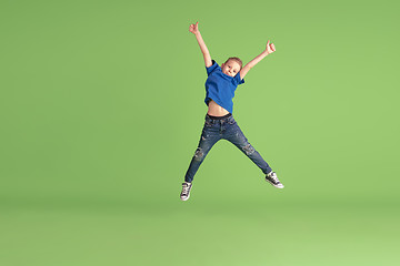 Image showing Happy boy playing and having fun on green studio background, emotions