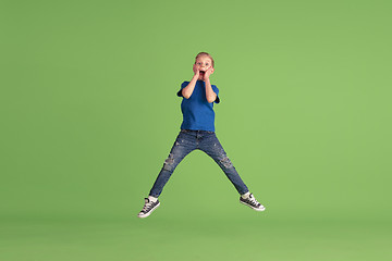 Image showing Happy boy playing and having fun on green studio background, emotions