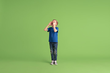 Image showing Happy boy playing and having fun on green studio background, emotions