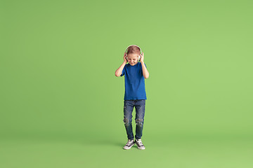 Image showing Happy boy playing and having fun on green studio background, emotions