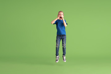 Image showing Happy boy playing and having fun on green studio background, emotions