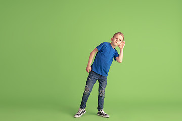 Image showing Happy boy playing and having fun on green studio background, emotions