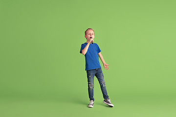 Image showing Happy boy playing and having fun on green studio background, emotions