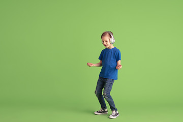 Image showing Happy boy playing and having fun on green studio background, emotions