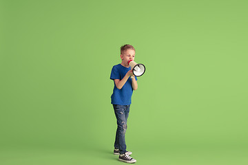 Image showing Happy boy playing and having fun on green studio background, emotions