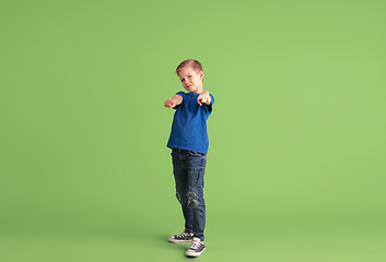 Image showing Happy boy playing and having fun on green studio background, emotions