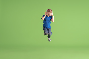 Image showing Happy boy playing and having fun on green studio background, emotions