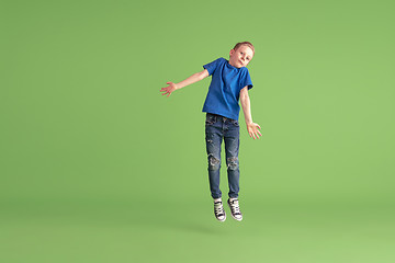 Image showing Happy boy playing and having fun on green studio background, emotions