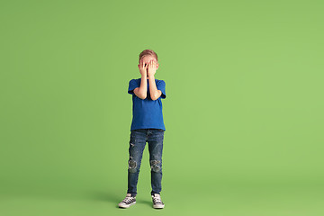 Image showing Happy boy playing and having fun on green studio background, emotions