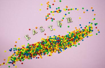 Image showing Abstract easter card with scattered color confectionery balls and letters. Easter holiday concept.