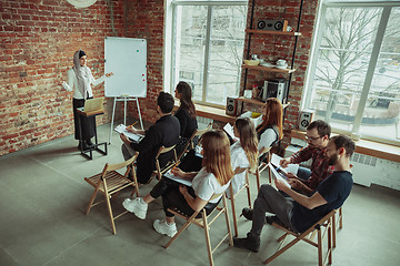 Image showing Female muslim speaker giving presentation in hall at university workshop