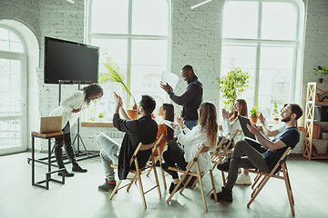 Image showing Female african-american speaker giving presentation in hall at university workshop