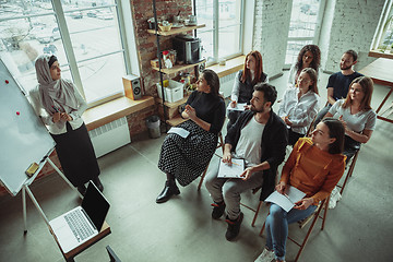 Image showing Female muslim speaker giving presentation in hall at university workshop