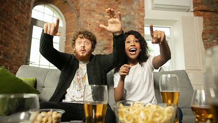 Image showing Excited couple, friends watching sport match, championship at home