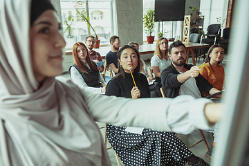 Image showing Female muslim speaker giving presentation in hall at university workshop