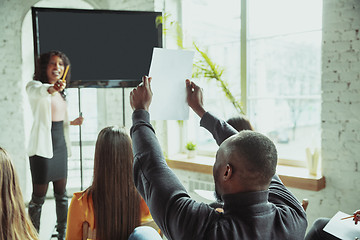 Image showing Female african-american speaker giving presentation in hall at university workshop