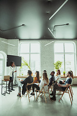 Image showing Female african-american speaker giving presentation in hall at university workshop