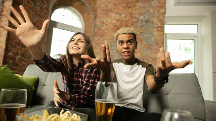 Image showing Excited couple, friends watching sport match, championship at home