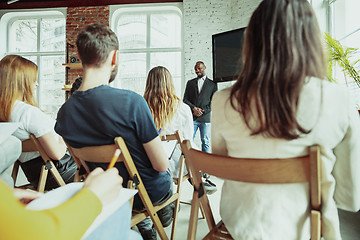 Image showing Male african-american speaker giving presentation in hall at university workshop