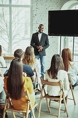 Image showing Male african-american speaker giving presentation in hall at university workshop