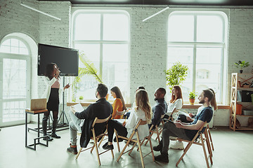 Image showing Female african-american speaker giving presentation in hall at university workshop