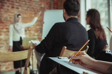 Image showing Female muslim speaker giving presentation in hall at university workshop