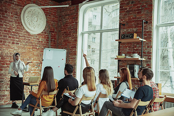 Image showing Female muslim speaker giving presentation in hall at university workshop