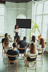 Image showing Female african-american speaker giving presentation in hall at university workshop