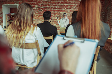 Image showing Female muslim speaker giving presentation in hall at university workshop