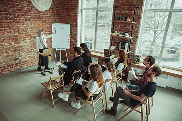 Image showing Female muslim speaker giving presentation in hall at university workshop