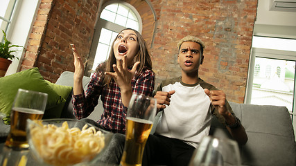 Image showing Excited couple, friends watching sport match, championship at home