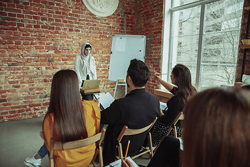 Image showing Female muslim speaker giving presentation in hall at university workshop